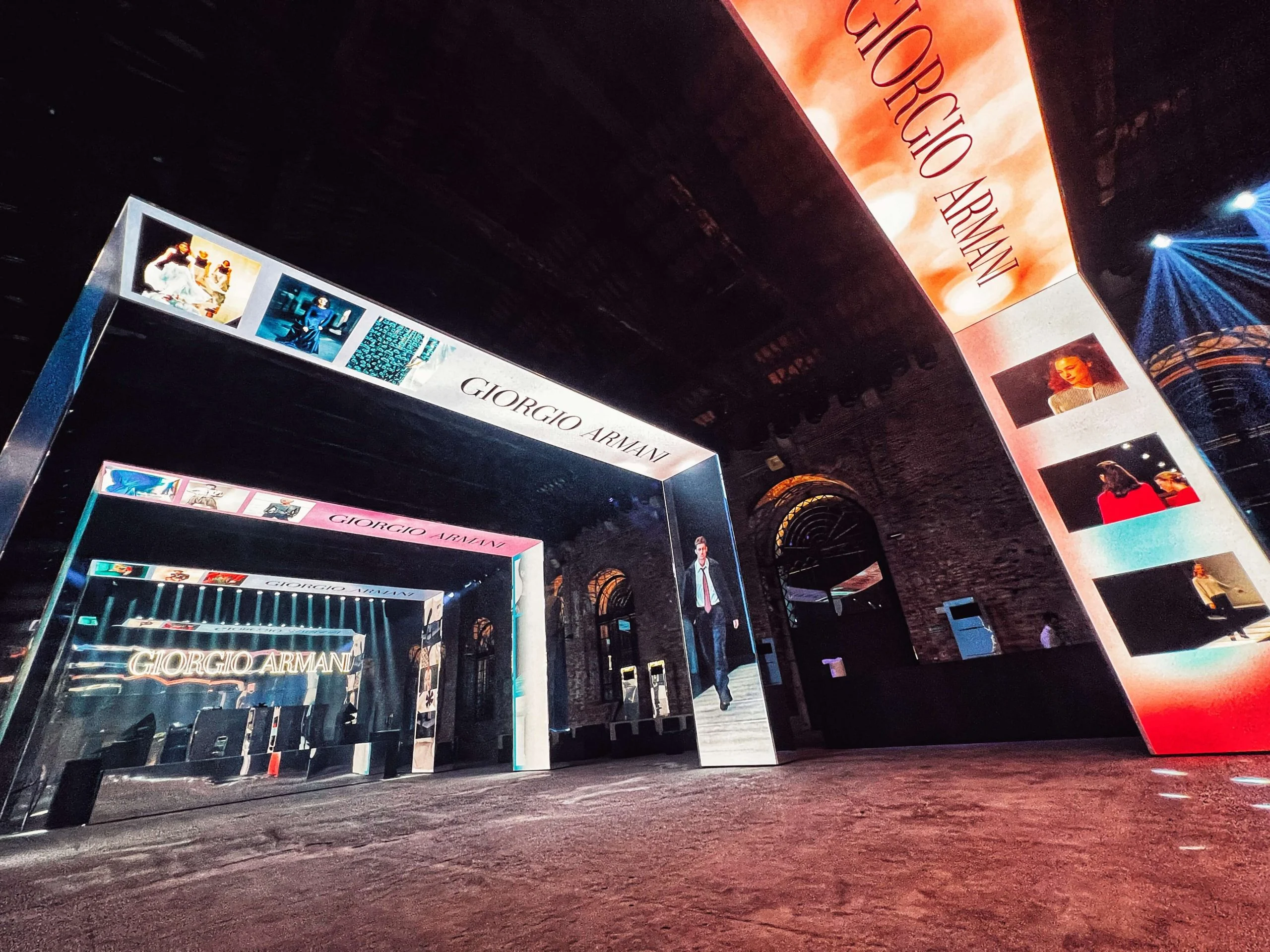 Vista grandangolare dell'ingresso del corridoio di portali, con un gigantesco pannello LED rosso con il nome Giorgio Armani – Festa Armani/Archivio alla Mostra del Cinema di Venezia, Italia, 2025 – progettazione di eventi