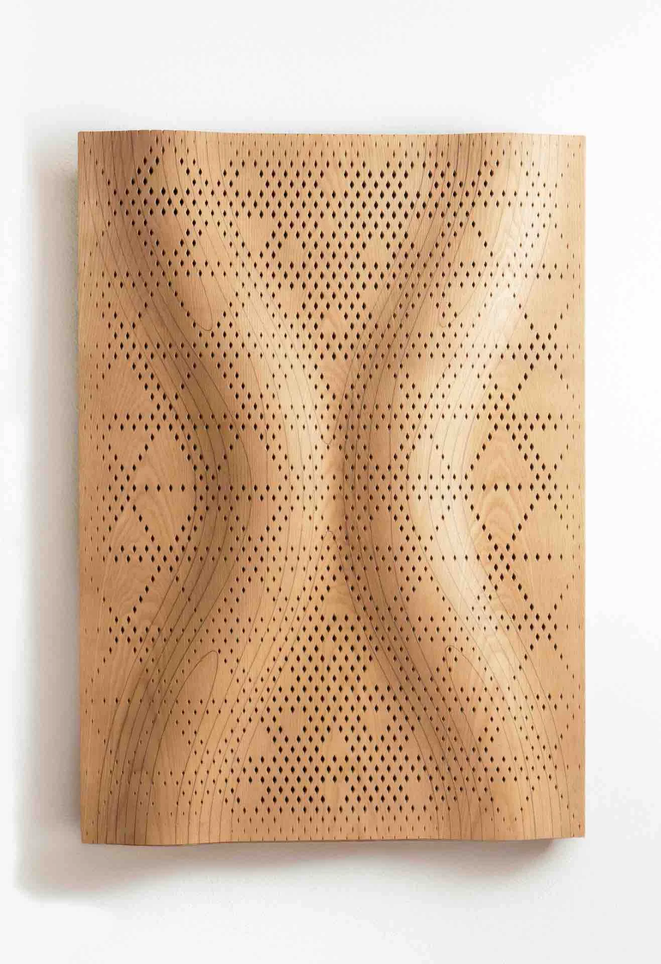 Pannello acustico ondulato in legno con un motivo a rombi Najdi traforato su una parete bianca – Pannelli acustici Najdi per Strong by Form, 2025 – design di prodotto