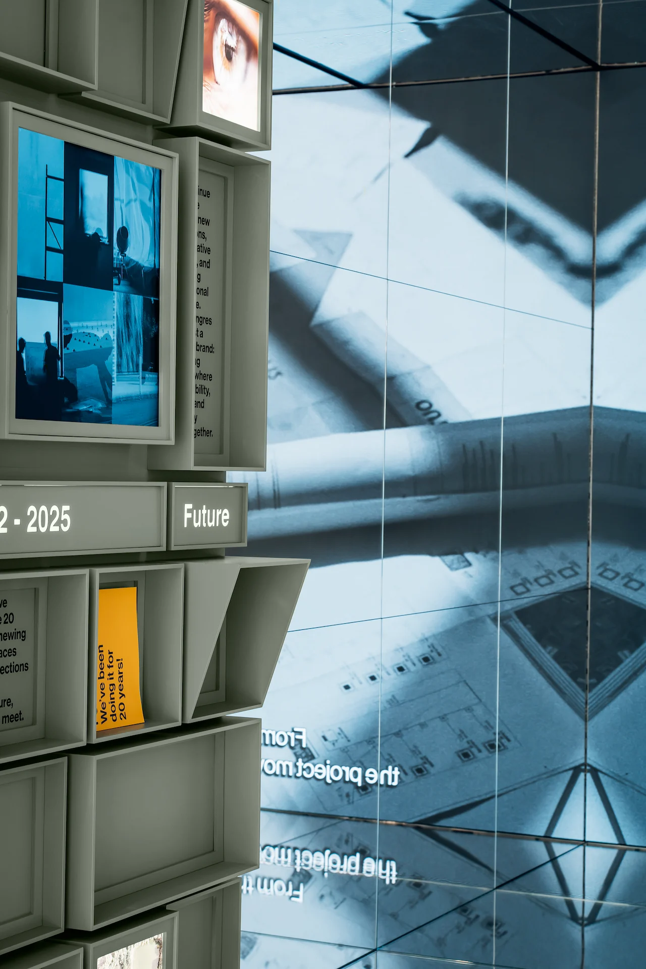 Bordo della parete di cubi con la scritta Future accanto a un grande videowall con disegni tecnici – Porcelaingres Brand Narrative Space, Castellarano, Italia, 2025 – progettazione di showroom