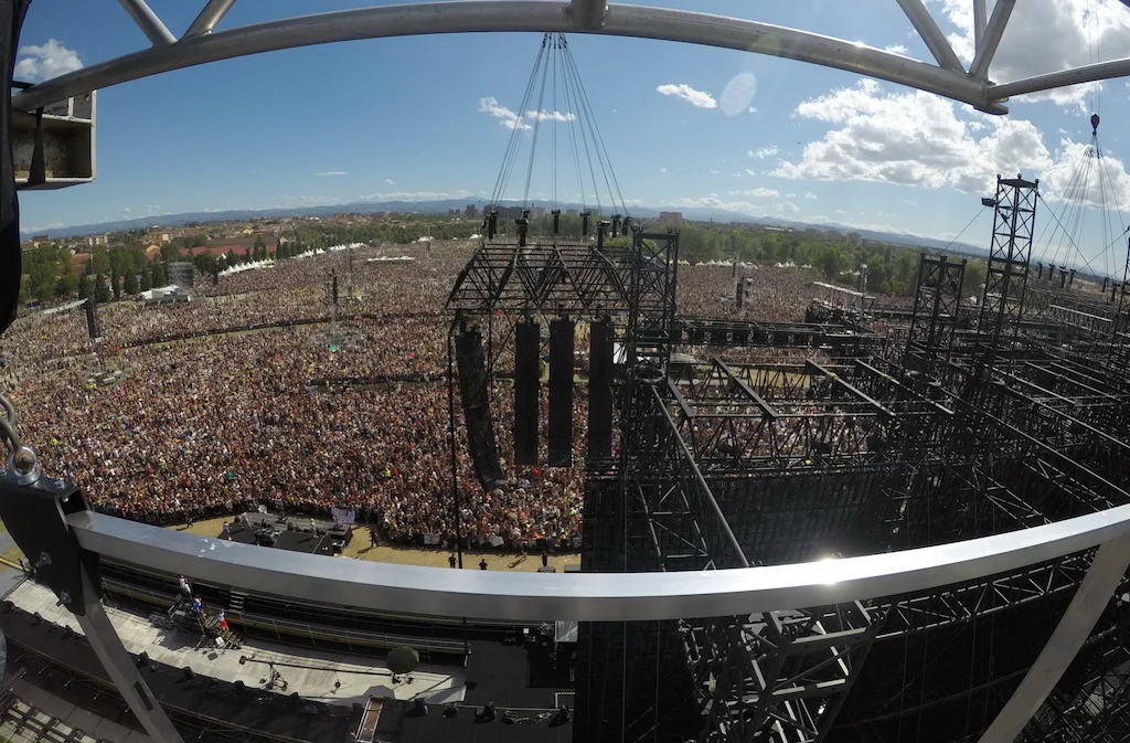 Vista fisheye dalla cima del palco sull'immensa folla del Modena Park, con torri di americane e casse sospese – Vasco Rossi Modena Park, Italia, 2017 – scenografia per concerti