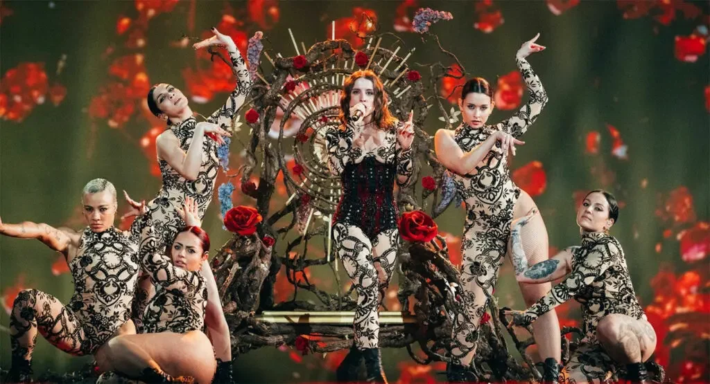 Angelina Mango su un trono di rami e rose rosse, circondata da ballerine in body di pizzo nero – Angelina Mango all'Eurovision 2024, Malmö, Svezia – scenografia per concerti