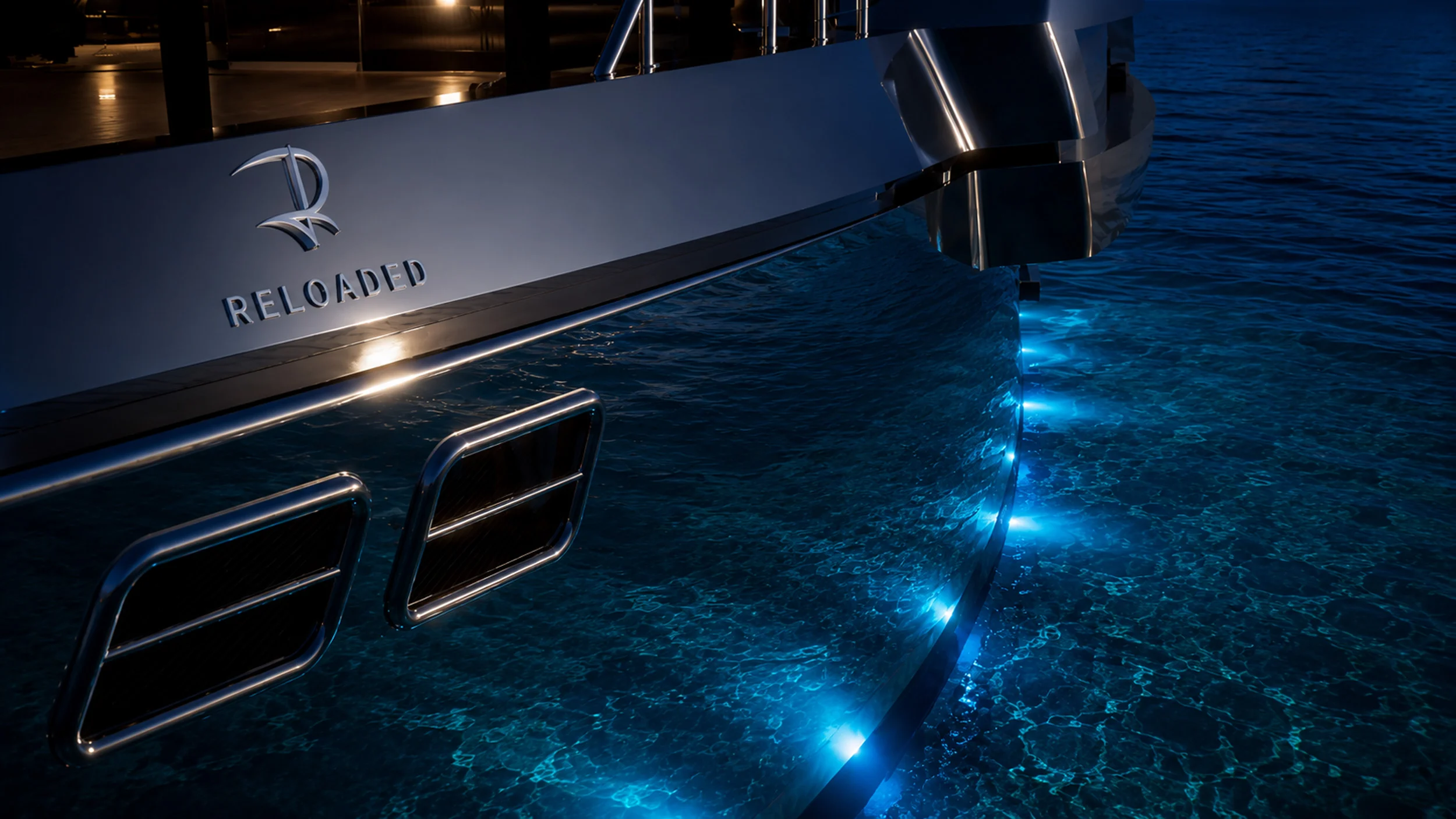 Render della poppa di notte: logo Reloaded sullo scafo e luci subacquee blu nel mare – Morricone Reloaded, Flexplorer 146, 2026 – interior design di yacht, concorso